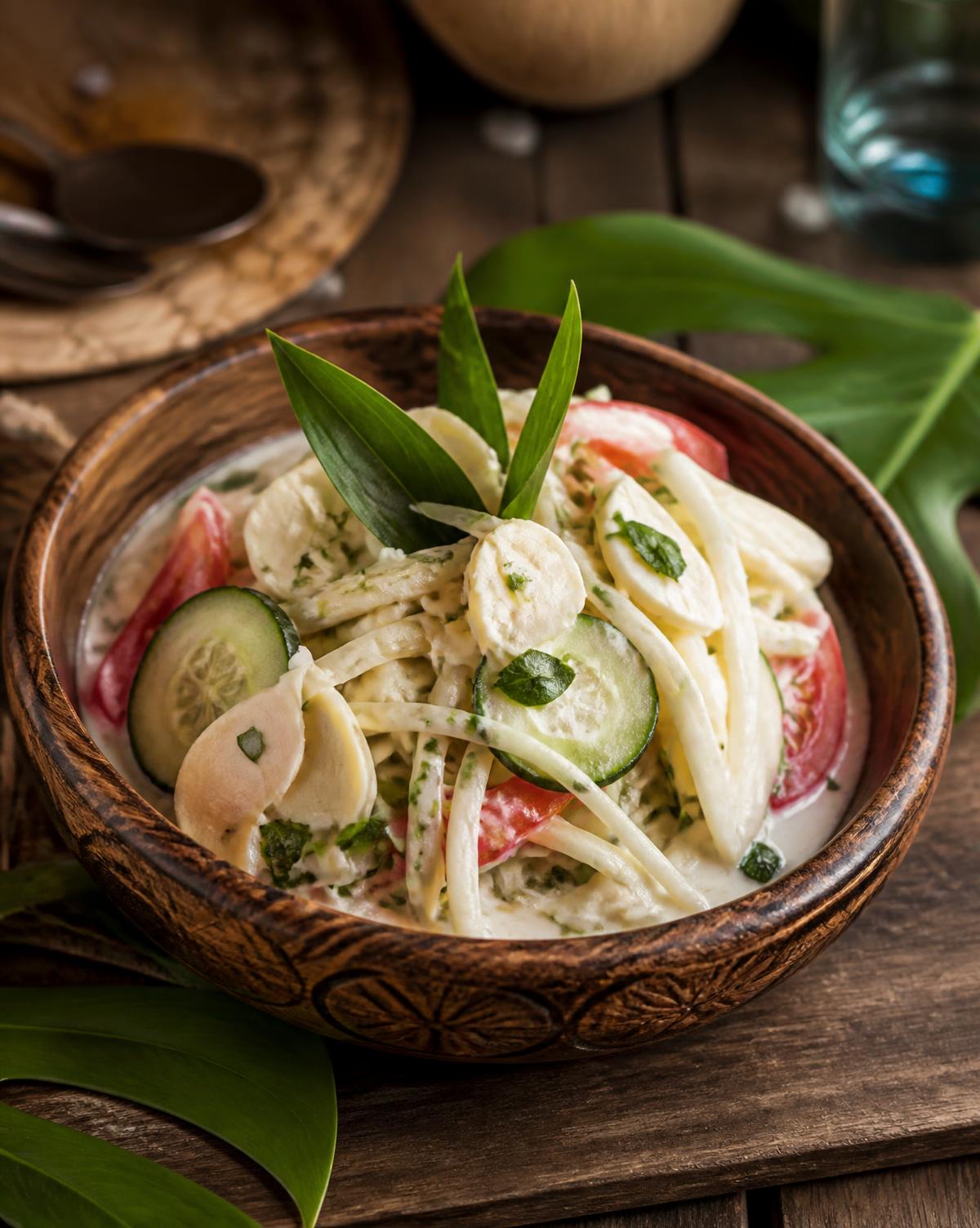 A vegan Tahitian hearts of palm and coconut milk salad served in a carved wooden bowl